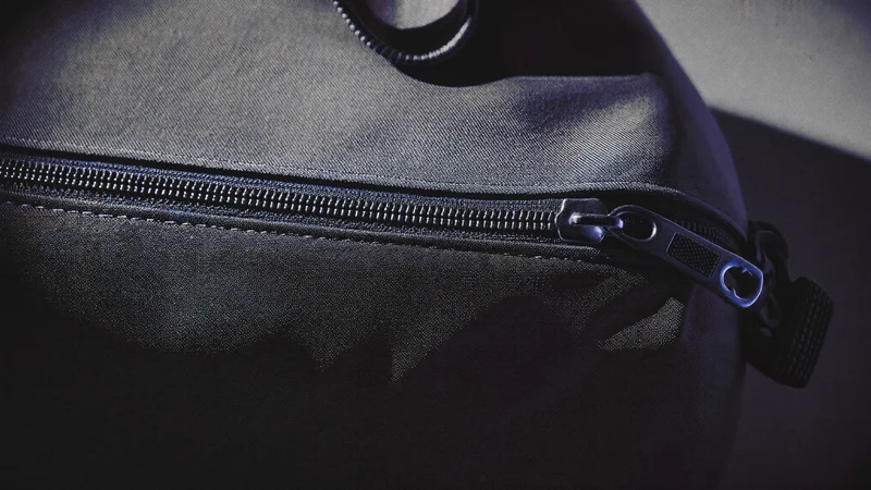 Nahaufnahme von Nylon-Gewebe, Reißverschluss und Nähten eines Reisebeutels